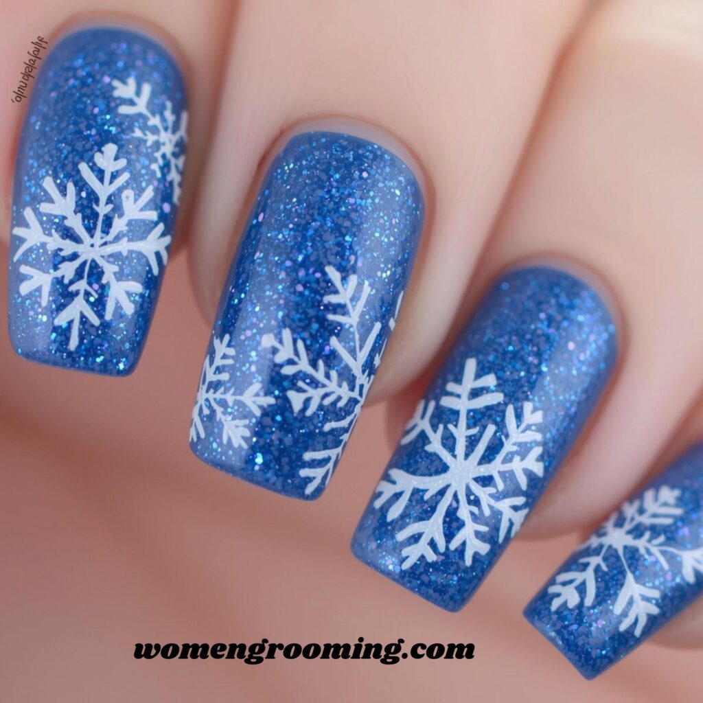 16. Blue Glitter Snowflake Nails